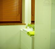 część wc w łazience, okna drewniane żaluzje imitujące drewno