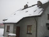 dom od przodu przykryty śniegiem