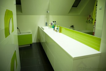 zielona łazienka na poddaszu białe meble i czarna podłowa