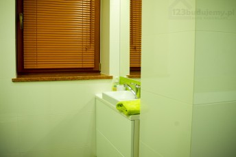 część wc w łazience, okna drewniane żaluzje imitujące drewno