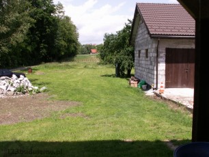 widok z tarasu na działkę i garaż