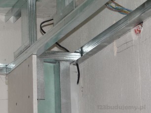 na około ściany sufit podwieszany obniżony z oświetleniem pionowe kolumny zabudowa geberita