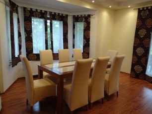 stół w salonie, krzesła pokryte ekoskórą zasłony ekrany firanki, aranżacja