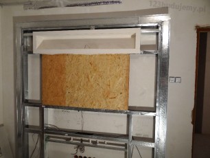 ścianka z wnękami w formie półek tworząca zabudową telewizora