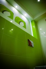 wc podwieszane muszla kolo zielone płytki w kropki duże dekory na środku ściany