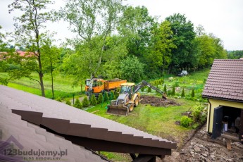 widok z okna dachowego na ekipę wykonującą prace ziemne