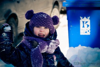 Zuzia przed domem, w tle widać śmietnik mpo