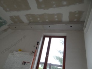 ozdobna konstrukcja nad wyjściem na balkon, nad oknem z oświetleniem halogenowym