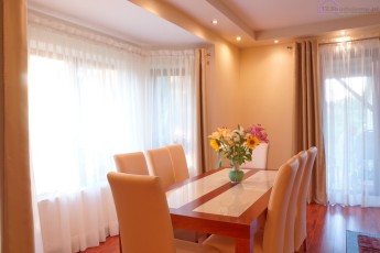 drewniany stół z krzesłami obitymi ekoskórą aranżacja salonu