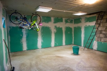 wykończeniówka w garażu, przyklejanie płyt kartonowo gipsowych na ścianie